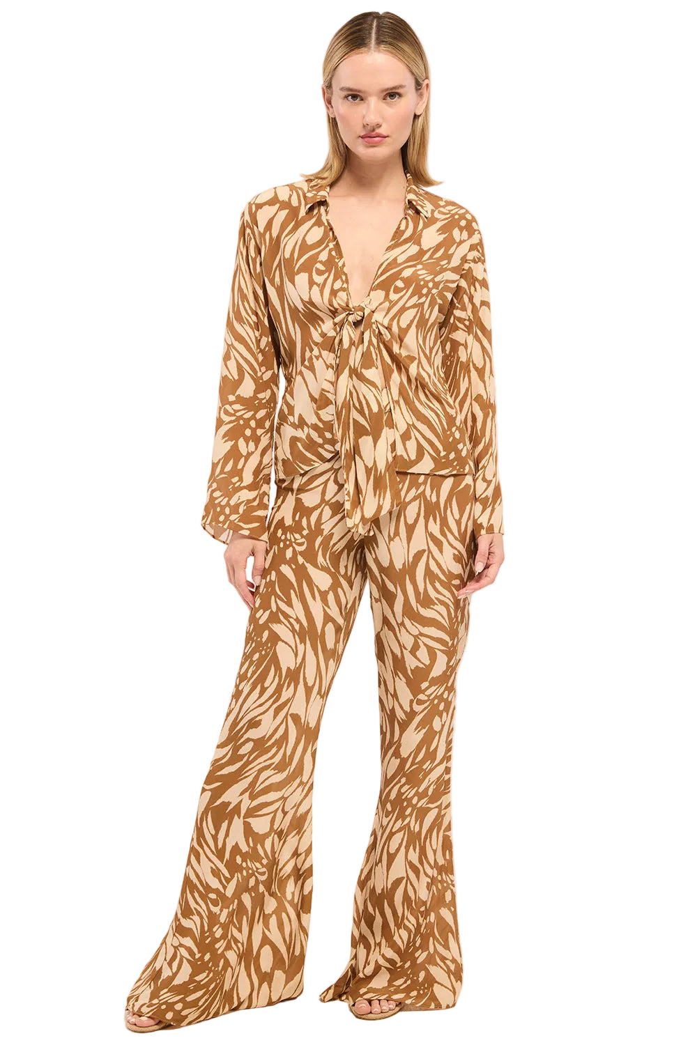 Woman wearing a brown patterned jumpsuit on a white background