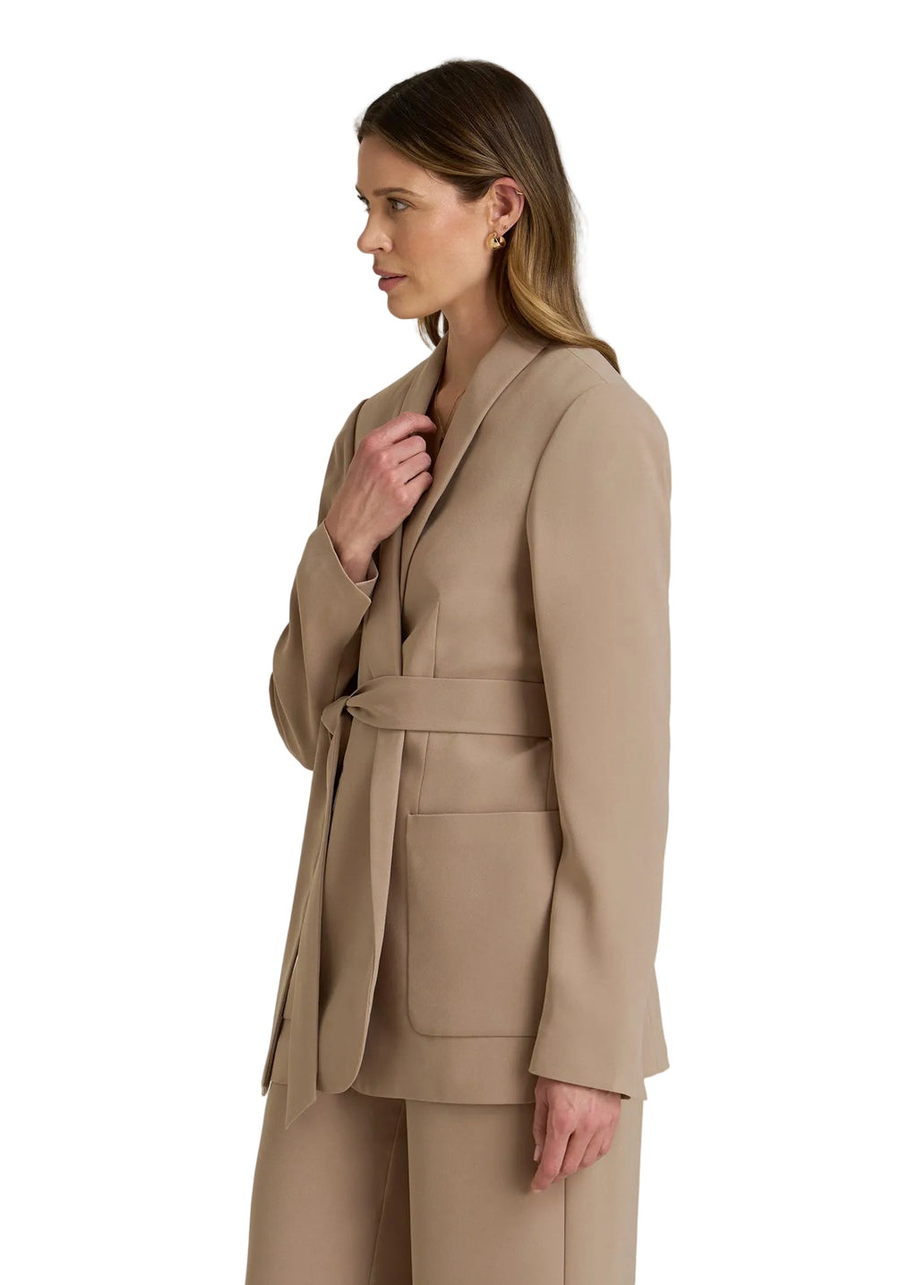 Woman wearing a beige suit on a plain background