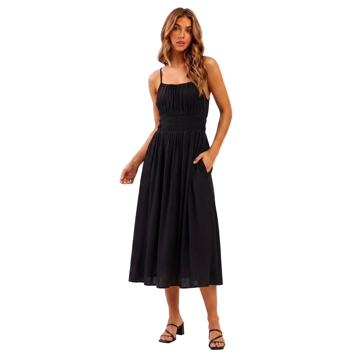 A woman modeling a black midi dress with thin straps, a gathered waist, and side pockets, standing against a plain light background. The brand name 'AURA' is printed in black serif text on the left side.