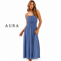 A woman modeling a sleeveless midi dress in dusty blue, featuring thin spaghetti straps, a smocked bodice, and side pockets. The brand name 'AURA' is printed in black serif font on the left side of the image, set against a plain white background.