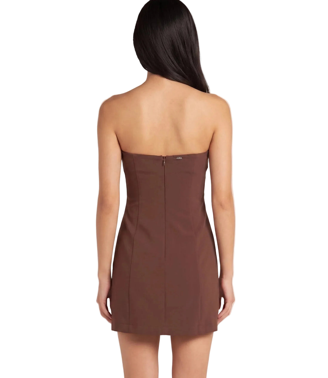 A woman modeling a strapless brown mini dress with a fitted bodice and flared skirt, standing against a light beige studio background. The brand name AURA is printed in dark gray on the left side.