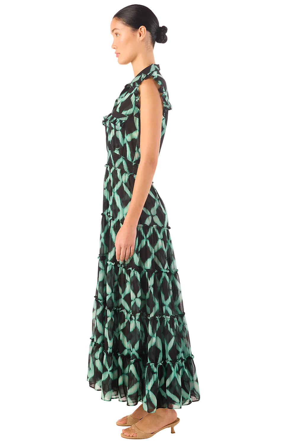 Woman wearing a green and black patterned dress on a white background