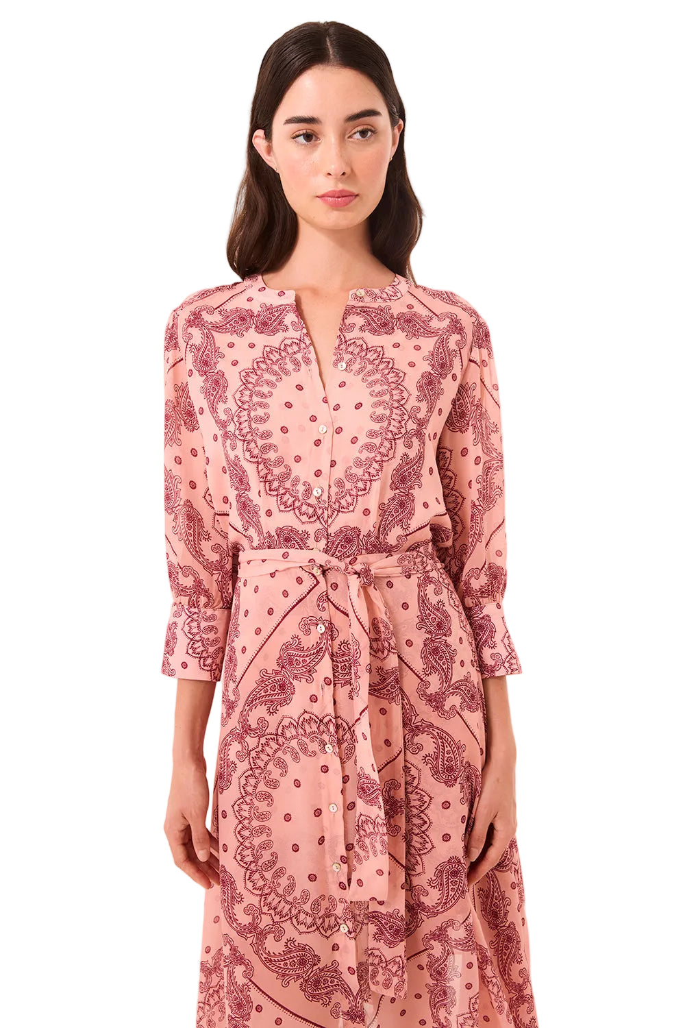 Woman wearing a pink patterned dress on a beige background