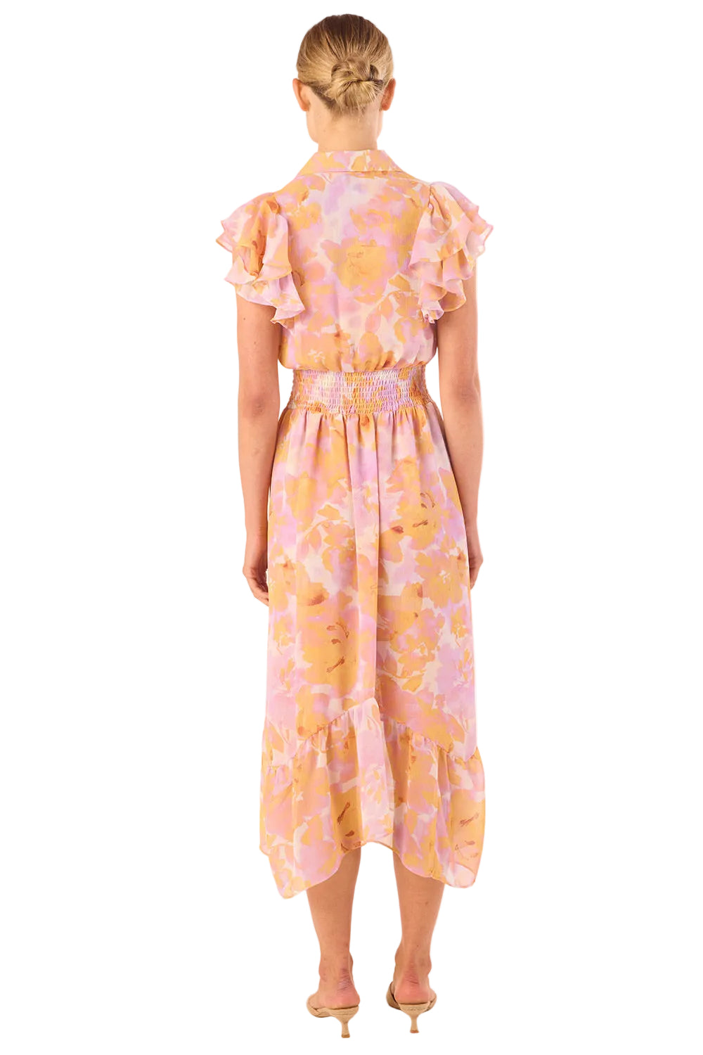 Woman wearing a floral dress with ruffled sleeves on a white background